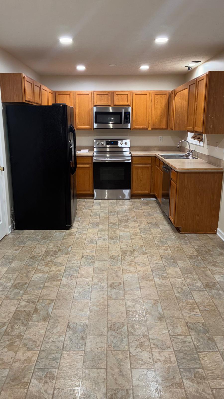 A tidy kitchen with clean floors and appliances