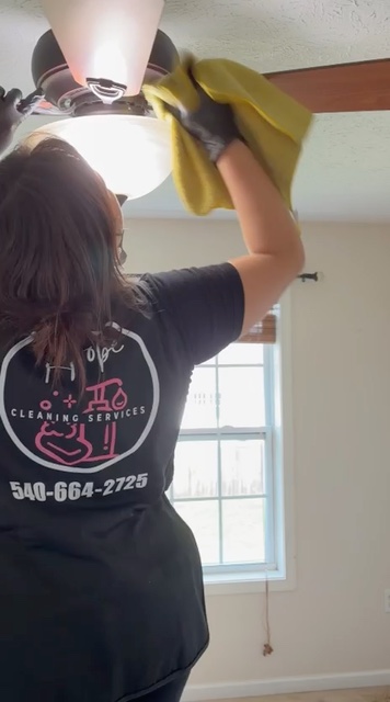 A Hope Cleaning team member dusting a ceiling fan
