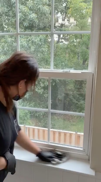 A Hope Cleaning team member cleaning a large window